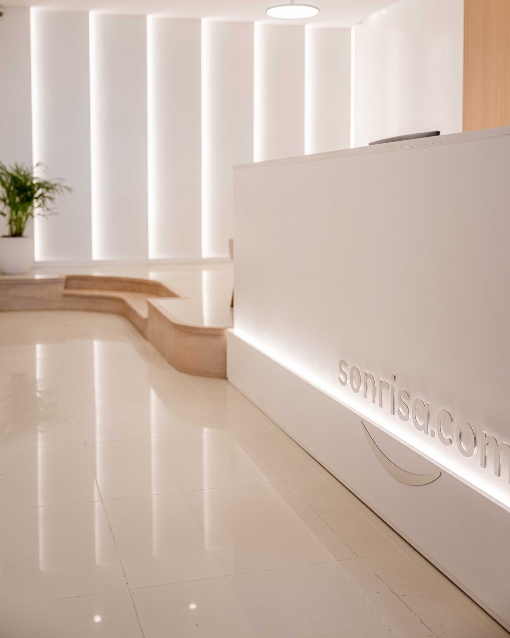 Recepción de la clínica Sonrisa con el logo sonrisa.com retroiluminado